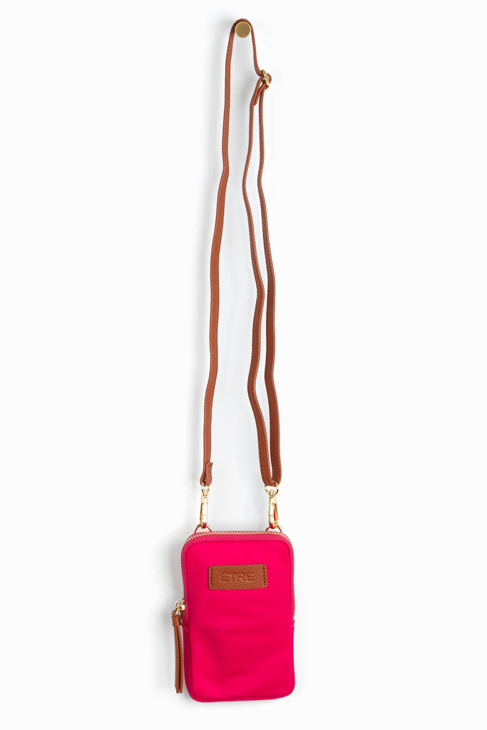 bright pink crossbody phone bag with tan accents and a tan removable adjustable crossbody strap