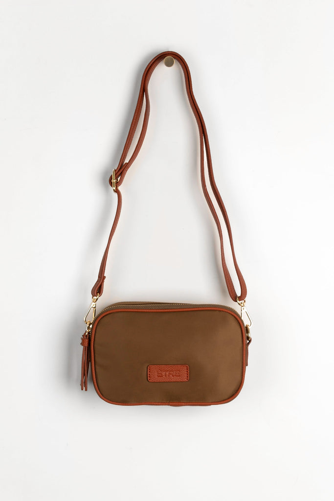 khaki crossbody bag with tan faux leather accents and a detachable strap