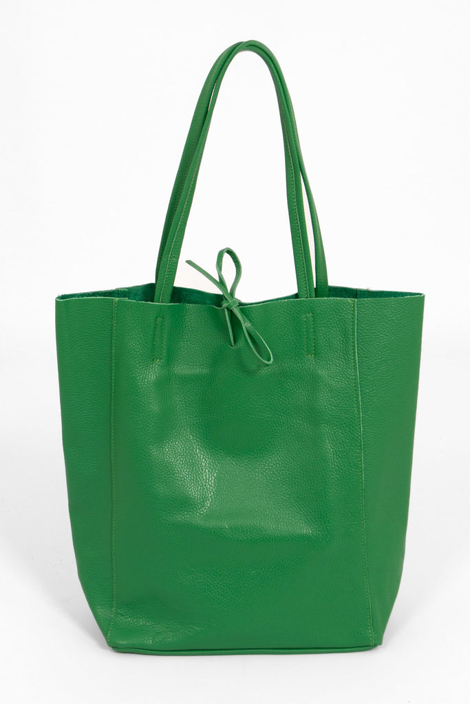 front view of a bright green pebbled leather tote bag with a top tie fastening and thin top carry handles. the bag is standing upright and the tie fastening is facing the camera.