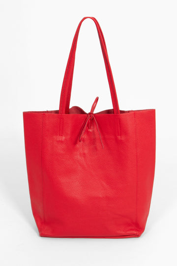 red pebbled leather tote bag with a top tie fastening and thin top carry handles.