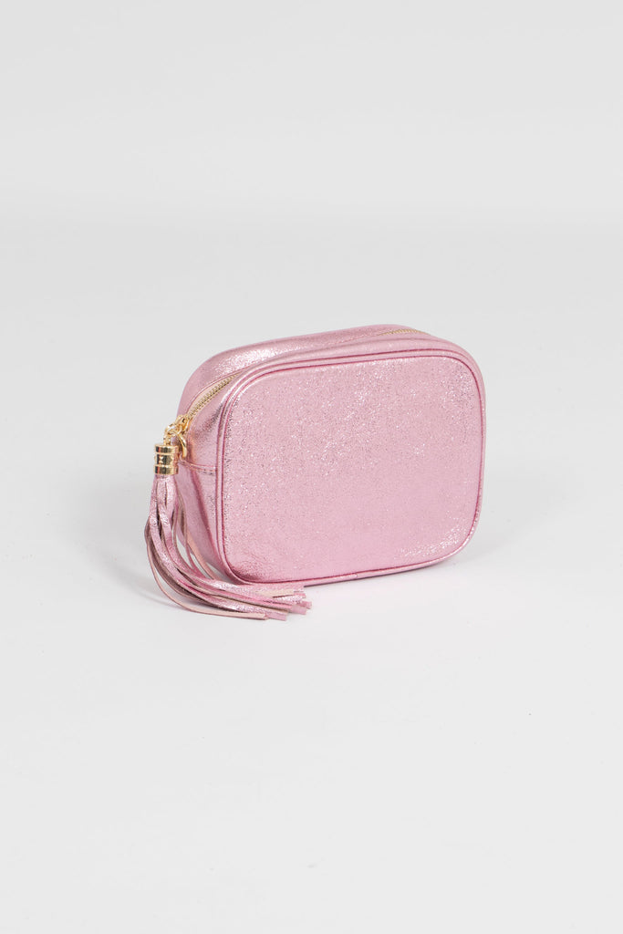 close up of metallic light pink leather crossbody camera bag with detachable bag strap