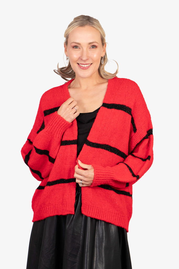 model wearing a red knitted open front cardigan with black glitter horizontal stripes