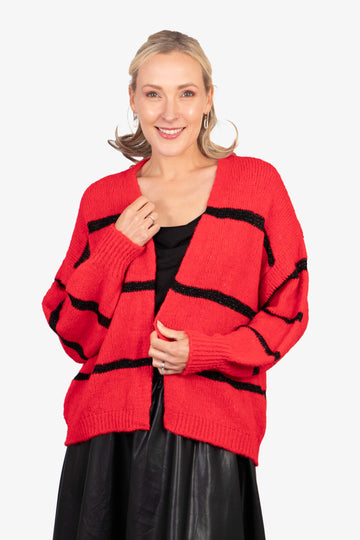 model wearing a red knitted open front cardigan with black glitter horizontal stripes