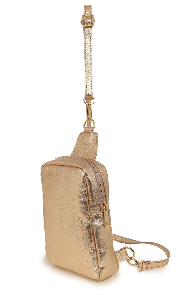 side view of gold sling bag showing the zip closure