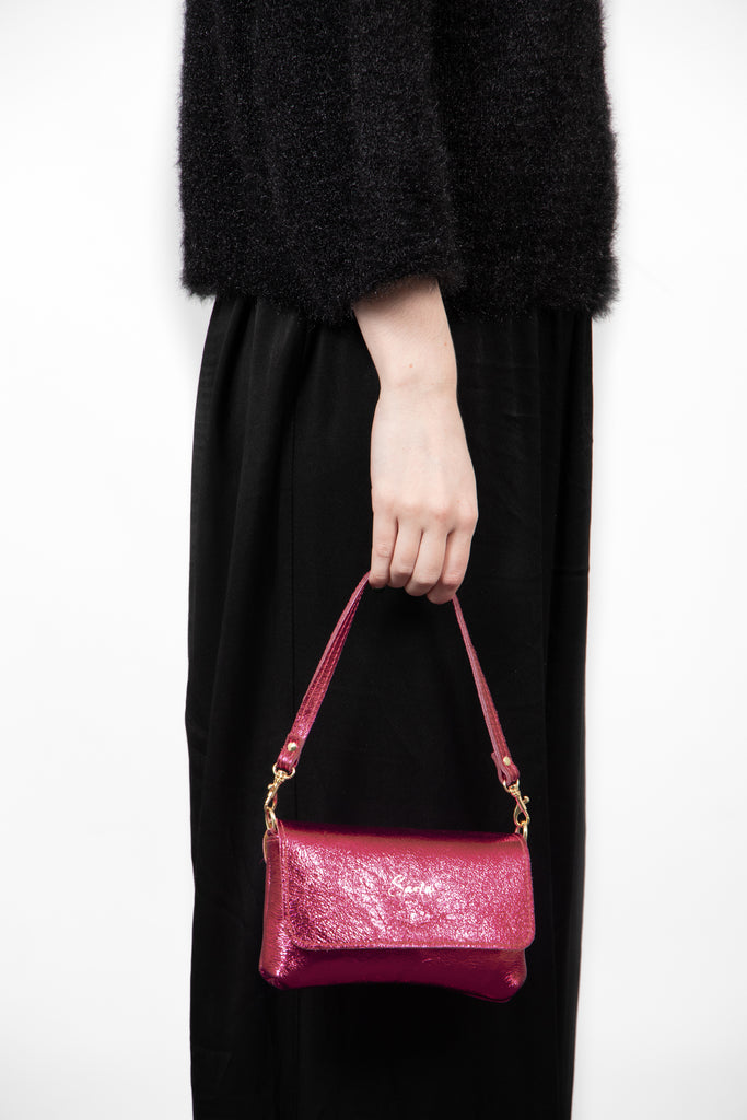 olga-metallic-italian-leather-mini-crossbody-bag-magenta-held-by-model
