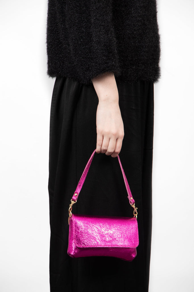 olga-metallic-italian-leather-mini-crossbody-bag-raspberry-held-by-model