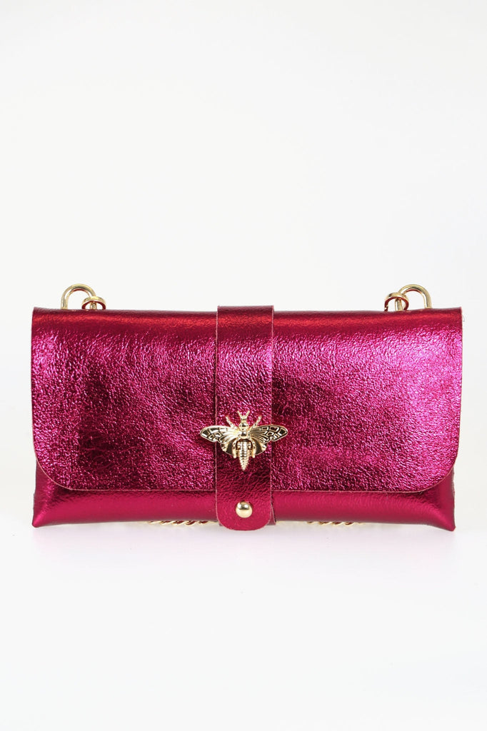 magenta pink leather clutch bag with a detachable crossbody gold chain strap and gold bee clasp on the front