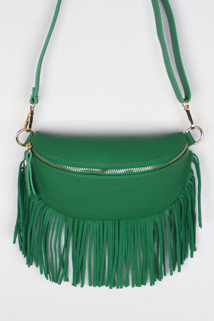 model wearing a bright green half moon cross body leather bag with a fringed trim and gold zip closure