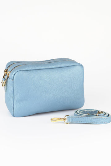 light blue leather camera bag with two zip closing compartments and a matching bag strap