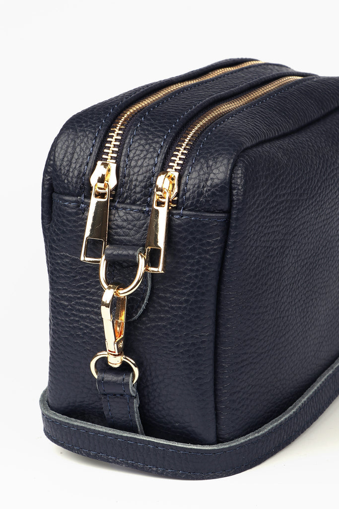 close up of the gold zip closures on the dual compartments of the leather handbag