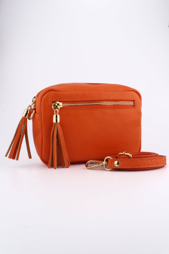 orange leather crossbody camera bag with a front zip pocket and matching detachable bag strap