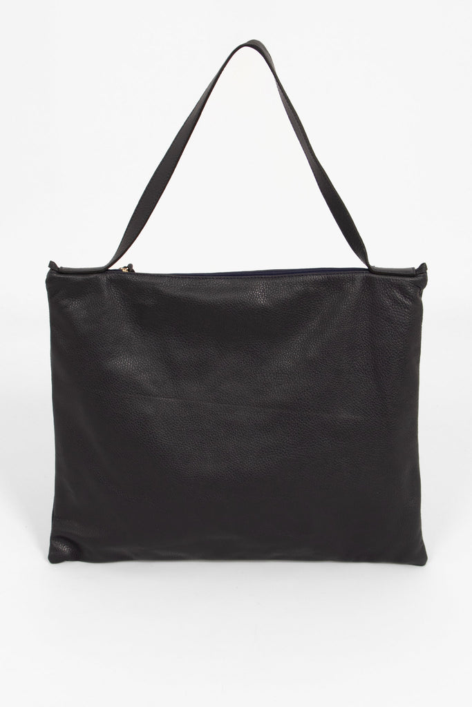 showing the back of the tote bag, the bag is made from pebbled navy blue leather