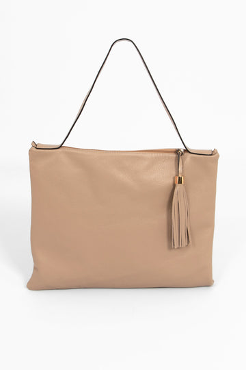 large taupe leather tote bag with a shoulder strap on the top of the bag and a decorative tassel on the front