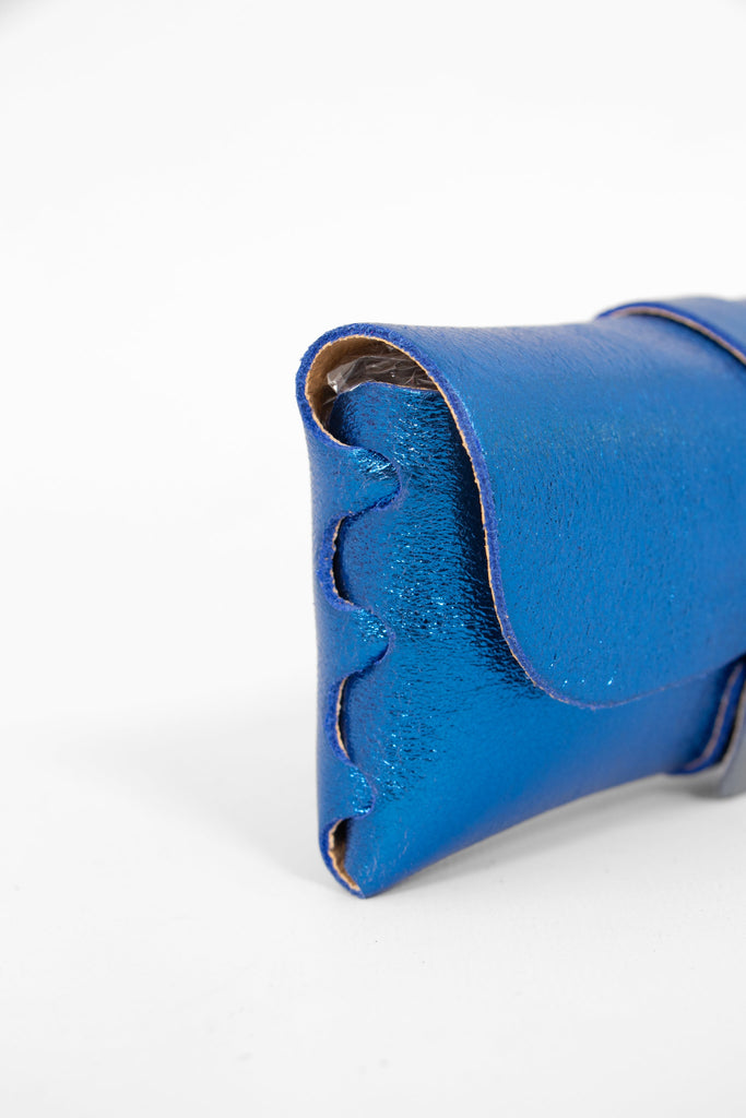 close up of the side view of the sunglasses case, showing the structure of the design. the case has a folding front which is secured by a button fastening