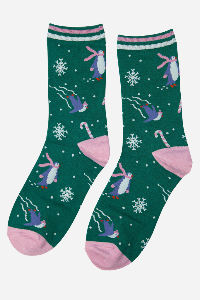 green and pink sparkly christmas socks with a pattern of snowflakes, penguins and candy canes