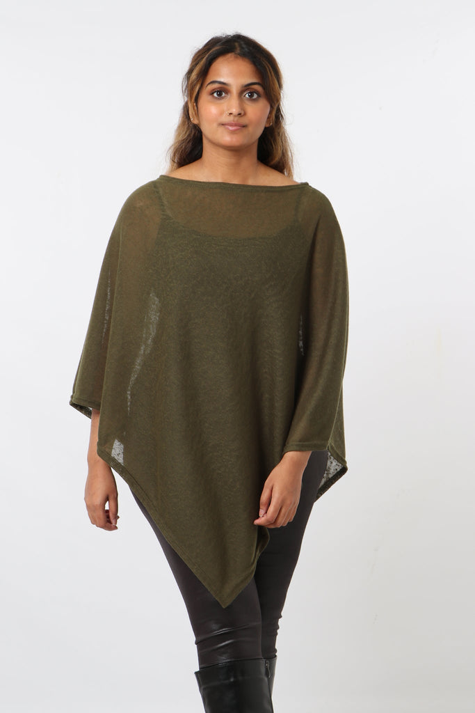 model wearing the plain khaki poncho styled with black trousers. the material of the poncho is lightweight and transparent