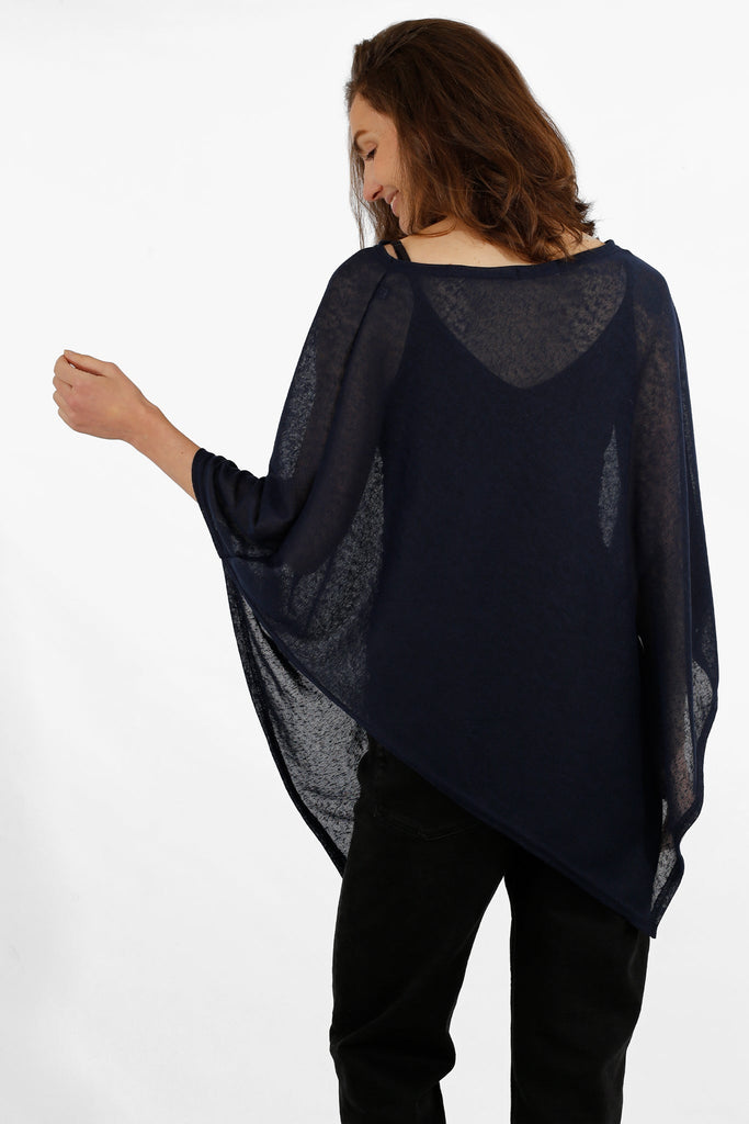 model showing the back of the plain navy poncho, showing the asymmetrical design