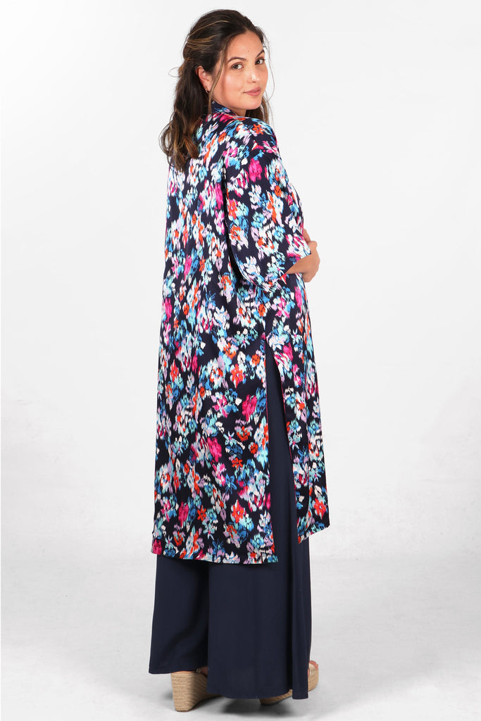 model showing the back of the abstract floral print kimono jacket, showing an all over colourful floral pattern