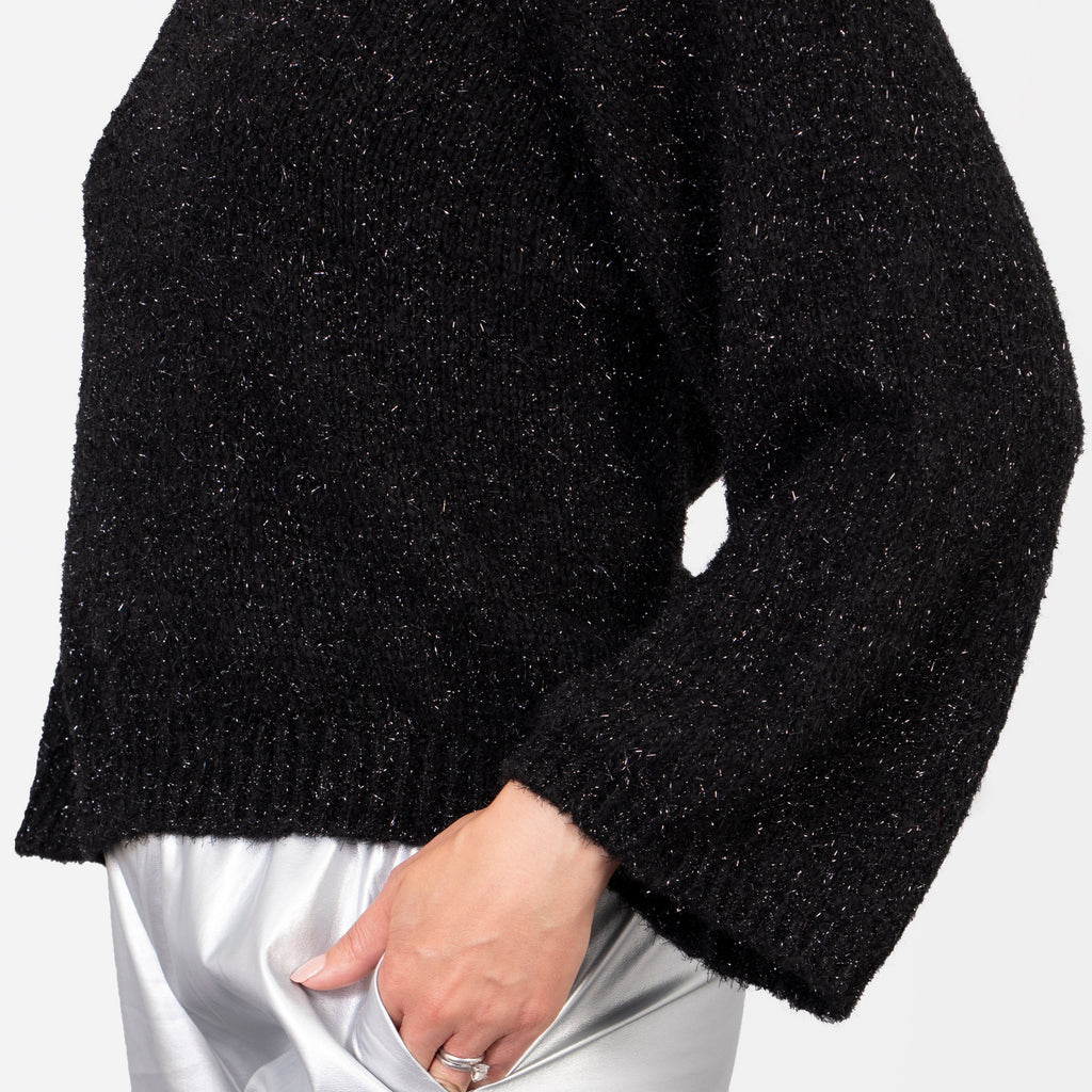 close up of the oversized loose sleeves on the black sparkly jumper