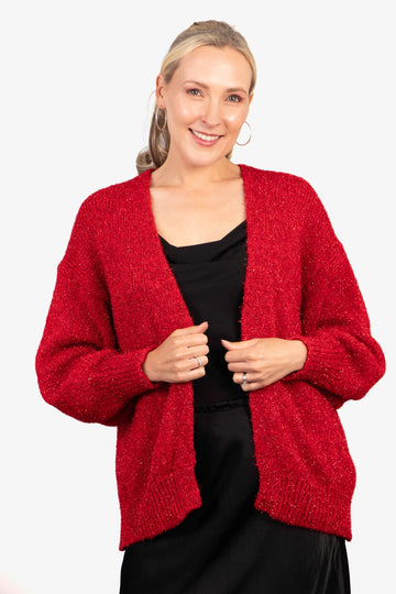 model wearing a gold sparkly tinsel effect knitted cardigan in red