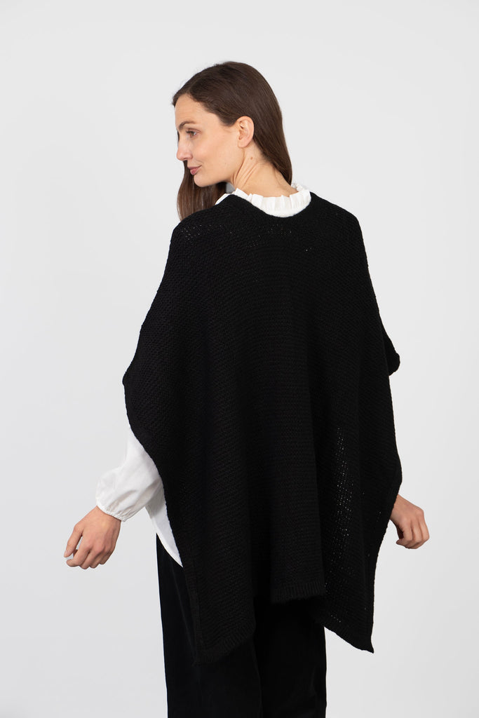 model showing the back of the wrap, it is plain black and the neck is round.