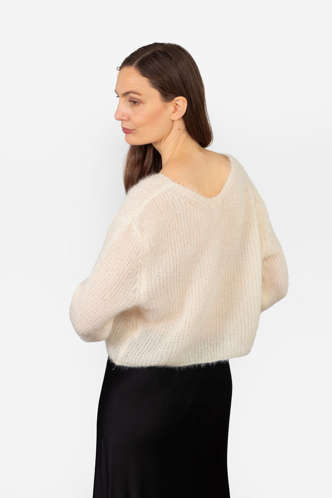 model showing the back of the cardigan, it is plain beige