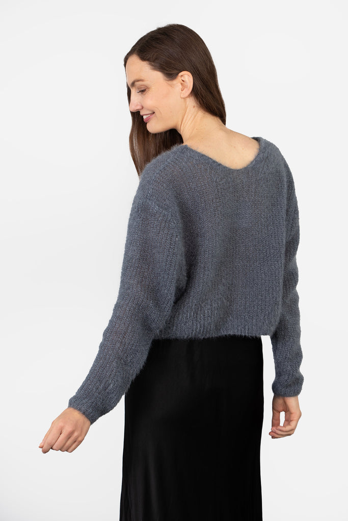 model showing the back of the cardigan, it is plain grey and with a round neck