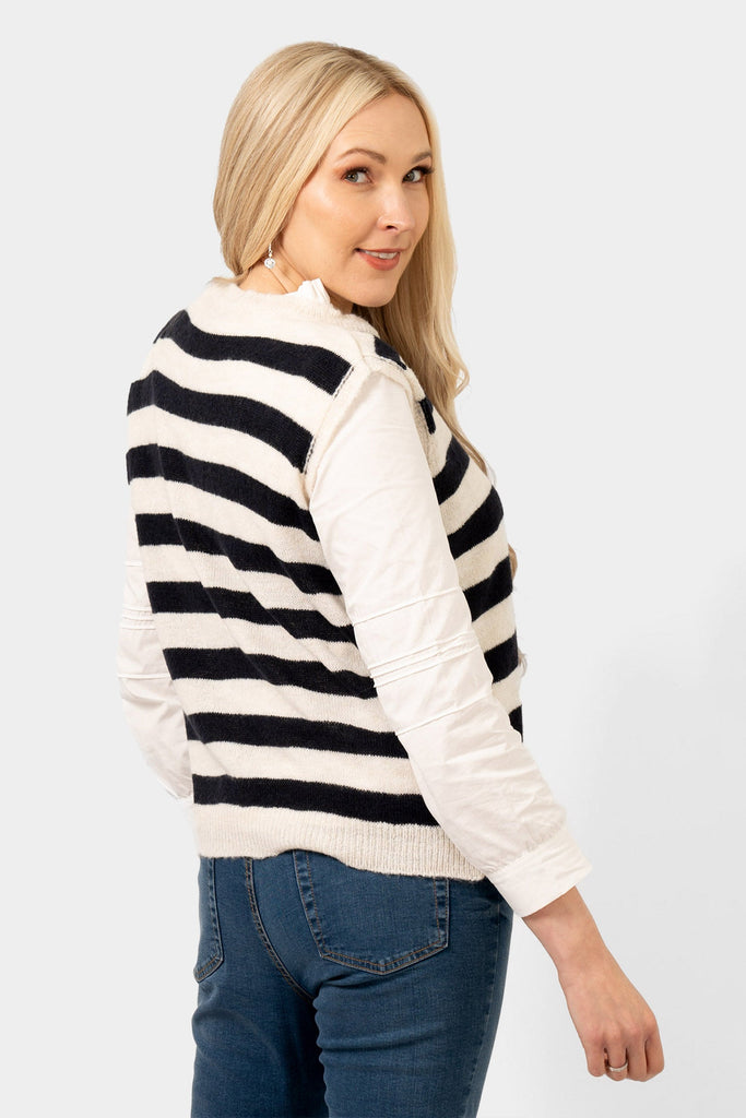 side view of the navy and cream knitted tank top. showing the sleeveless design of the knitwear piece.