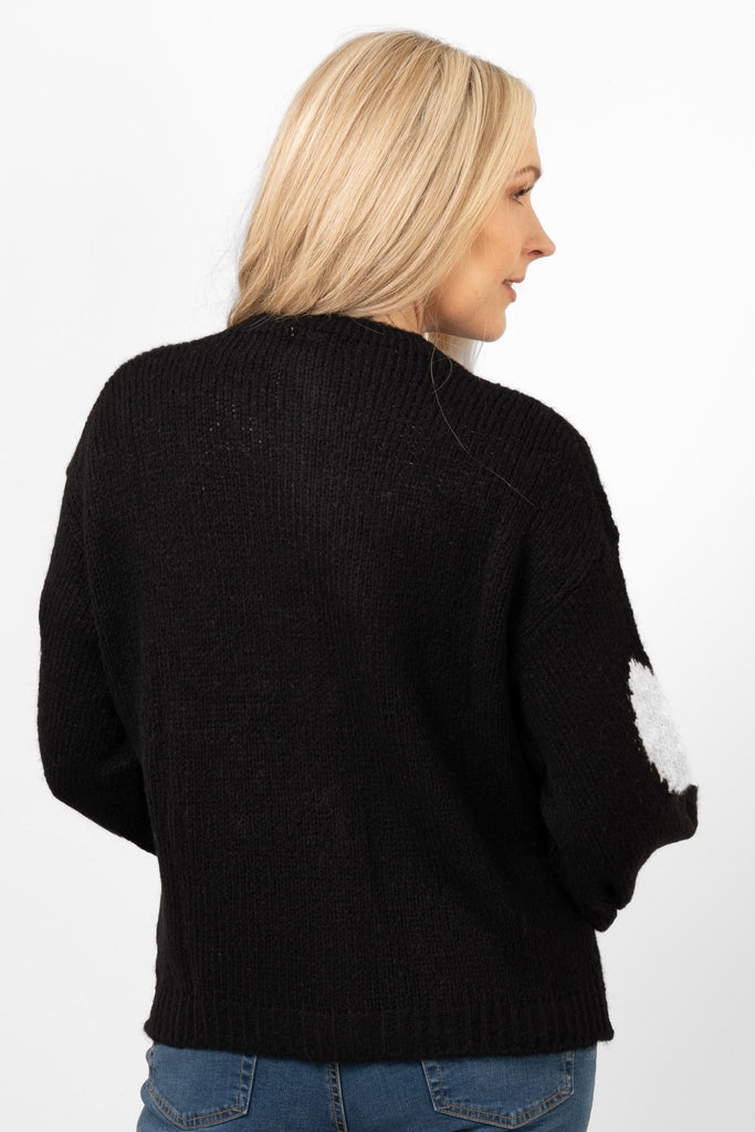showing the back of the cardigan. It is plain black, no pattern on the back.