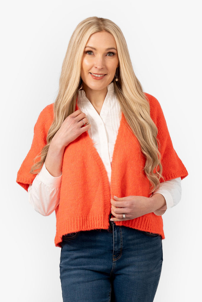 amelia-short-sleeve-wool-blend-cardigan-coral-model-showing-front-view-the-piece-has-an-open-front-and-v-neck