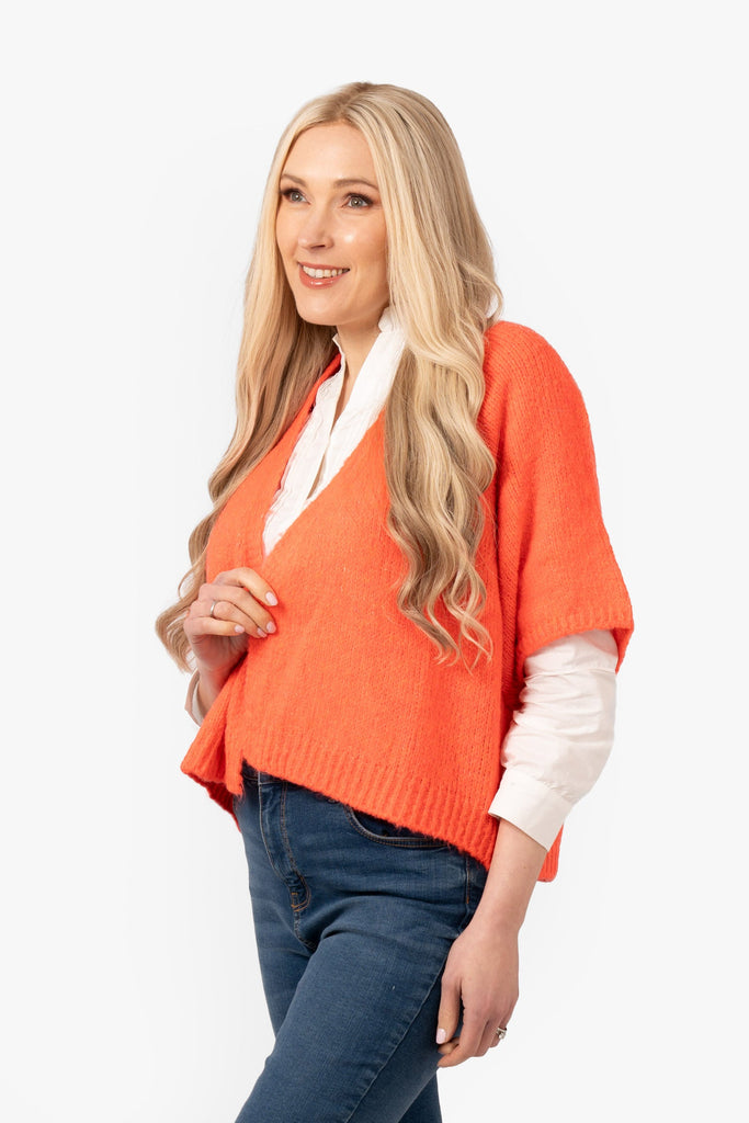 amelia-short-sleeve-wool-blend-cardigan-coral-model-showing-side-view-the-cardigan-has-loose-fitting-short-sleeves