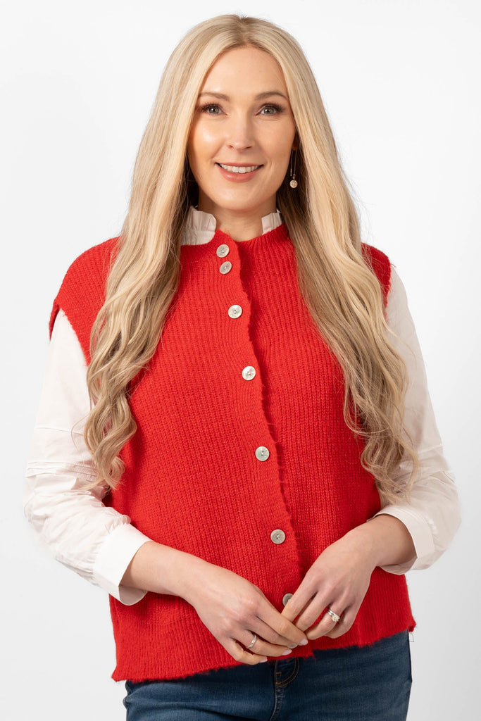 model wearing a red knitted tank top. the top has a round neck and a full button up front.