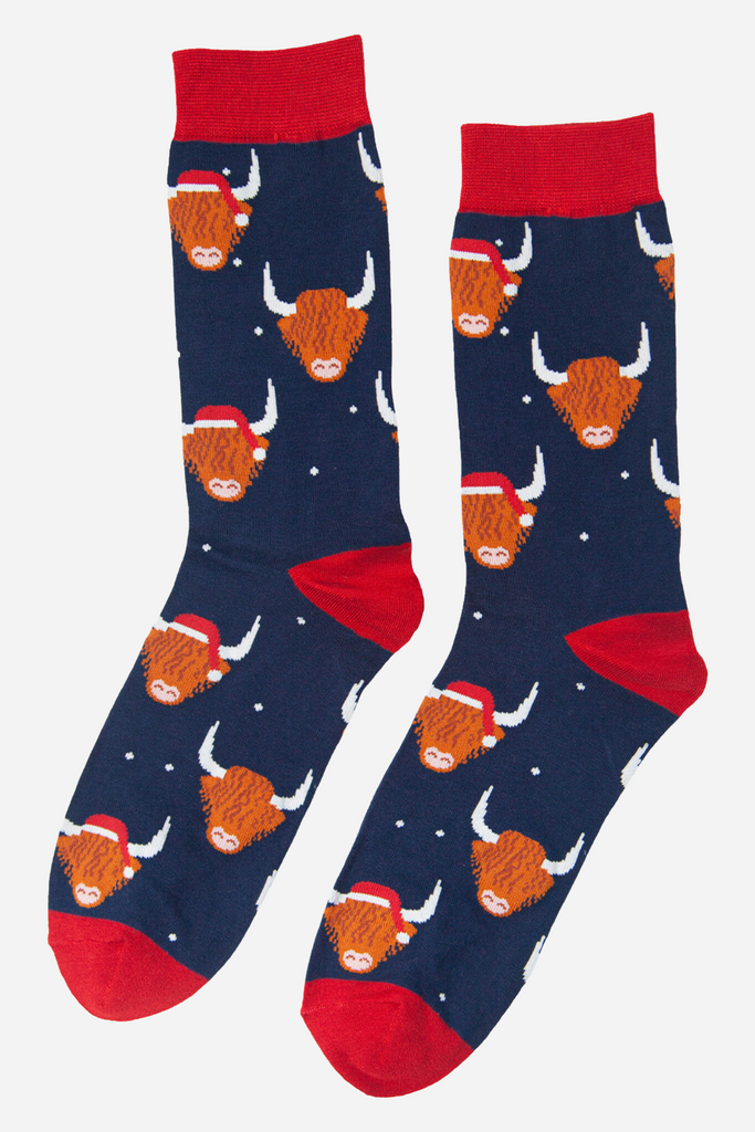 navy blue socks with red heel, toe and cuff with an all over pattern of highland cows wearing santa hats