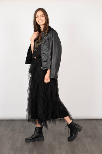 model wearing a black ruffled tulle midi skirt, accessorised with biker boots and a leather jacket