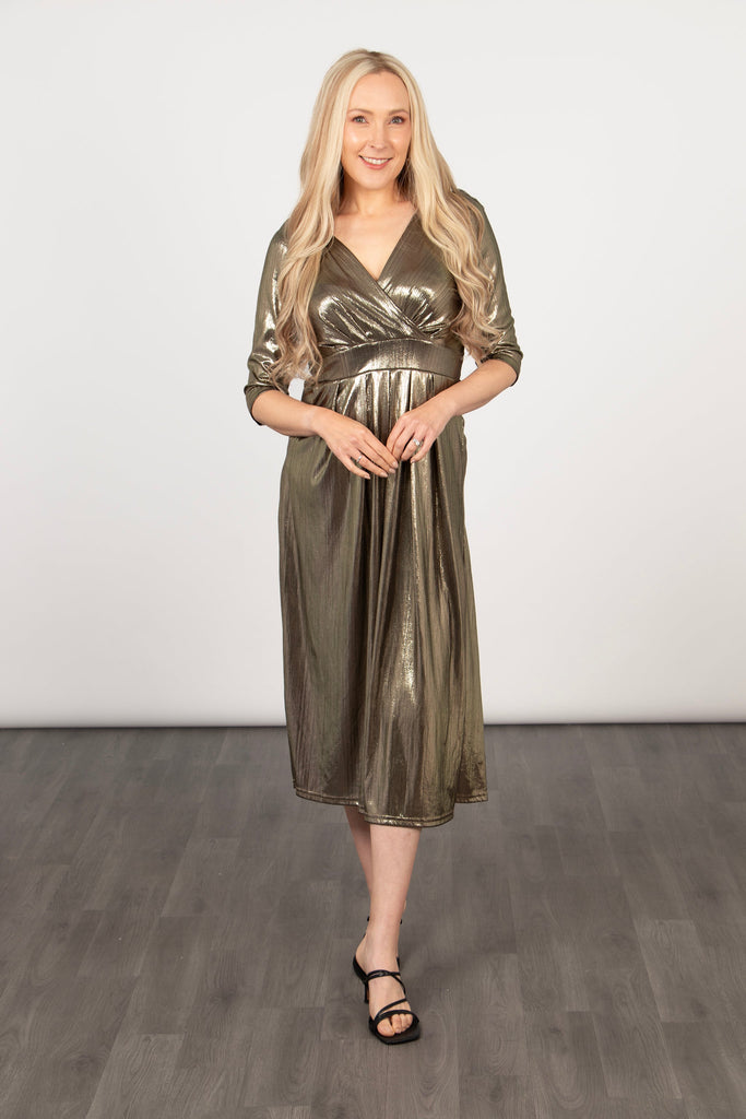 metallic gold jumpsuit with a v-neck and 3/4 sleeves worn by a model and accessorised with black heeled sandals