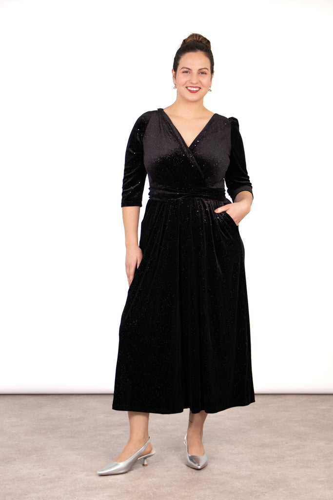 model wearing a black sparkly velvet cropped jumpsuit with a waist tie and v neck