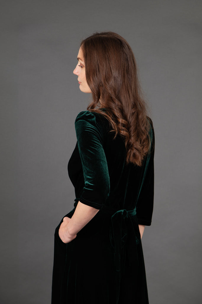 model showing the back of the jumpsuit with the waist tie feature, the 3/4 sleeves are also prominent in the image