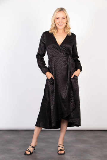 model wearing a black leopard print midi wrap dress with long sleeves and a v-neck