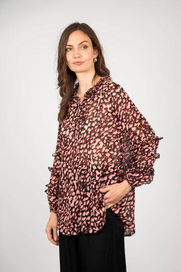 model wearing a pink chiffon leopard print blouse with long frilly sleeves