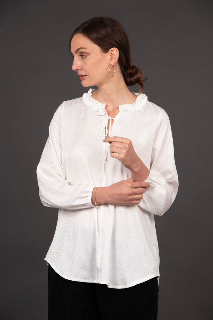 model wearing a white leopard print white blouse, showing the elasticated cuffs