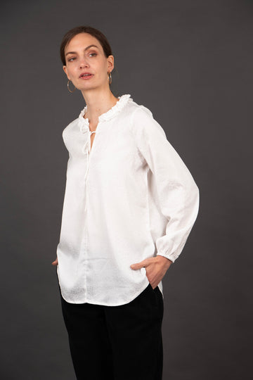 model wearing a long sleeve white leopard print blouse with a frill collar