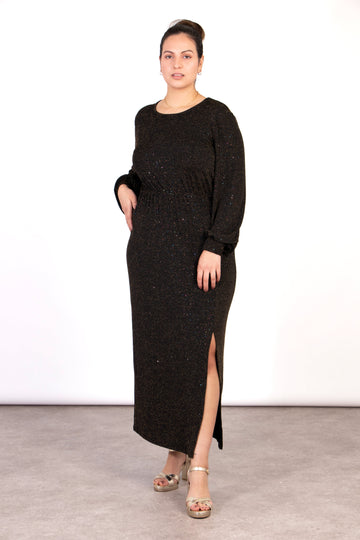 model wearing a black and bronze glitter sparkly long sleeve midi dress with a front split and round neck