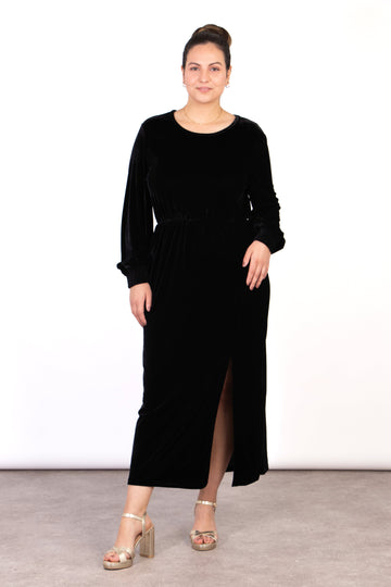 model wearing a long sleeved plain black midi dress with a front split and round neck