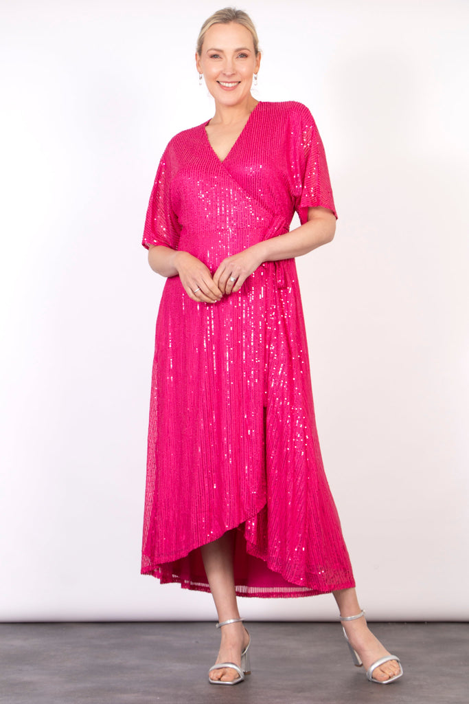 model wearing a pink sequin wrap dress with waist tie and v-neck 