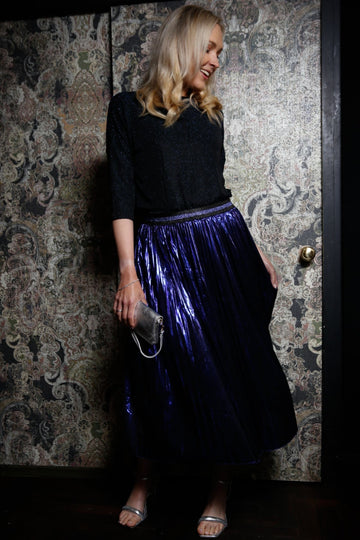 model wearing a blue pleated foil skirt with blue glitter waistband