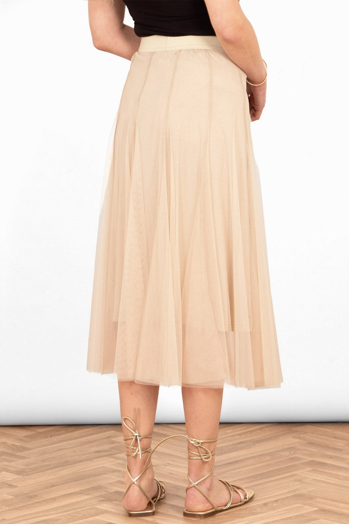 model wearing a plain cream layered tulle midi skirt with a matching red underskirt and elasticated waistband