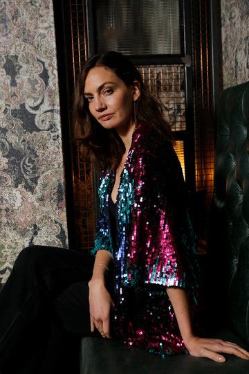 model wearing a pink and blue all over sequin blazer with 3/4 sleeves