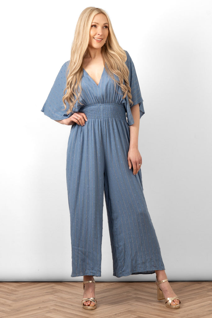 lyra-deep-v-neck-jumpsuit-denim-blue-metallic-stripe-on-model-front-view-shirred-waistband