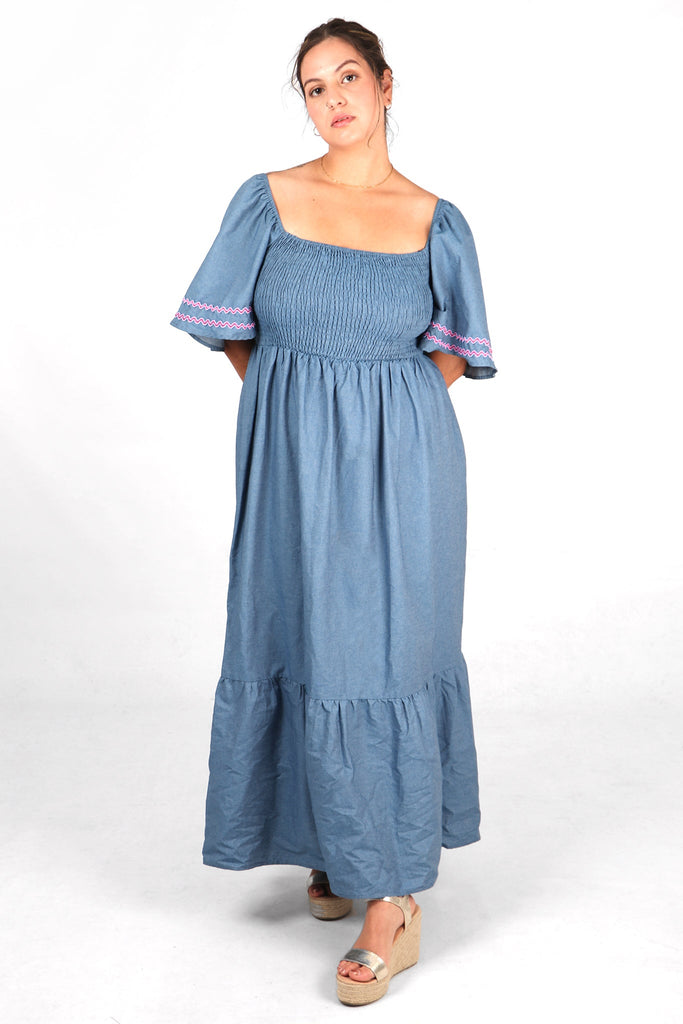 model wearing a denim blue cotton maxi dress with shirred bodice and square neck