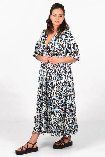 model wearing a blue ikat print maxi dress with fluted sleeves, v neck and shirred waist